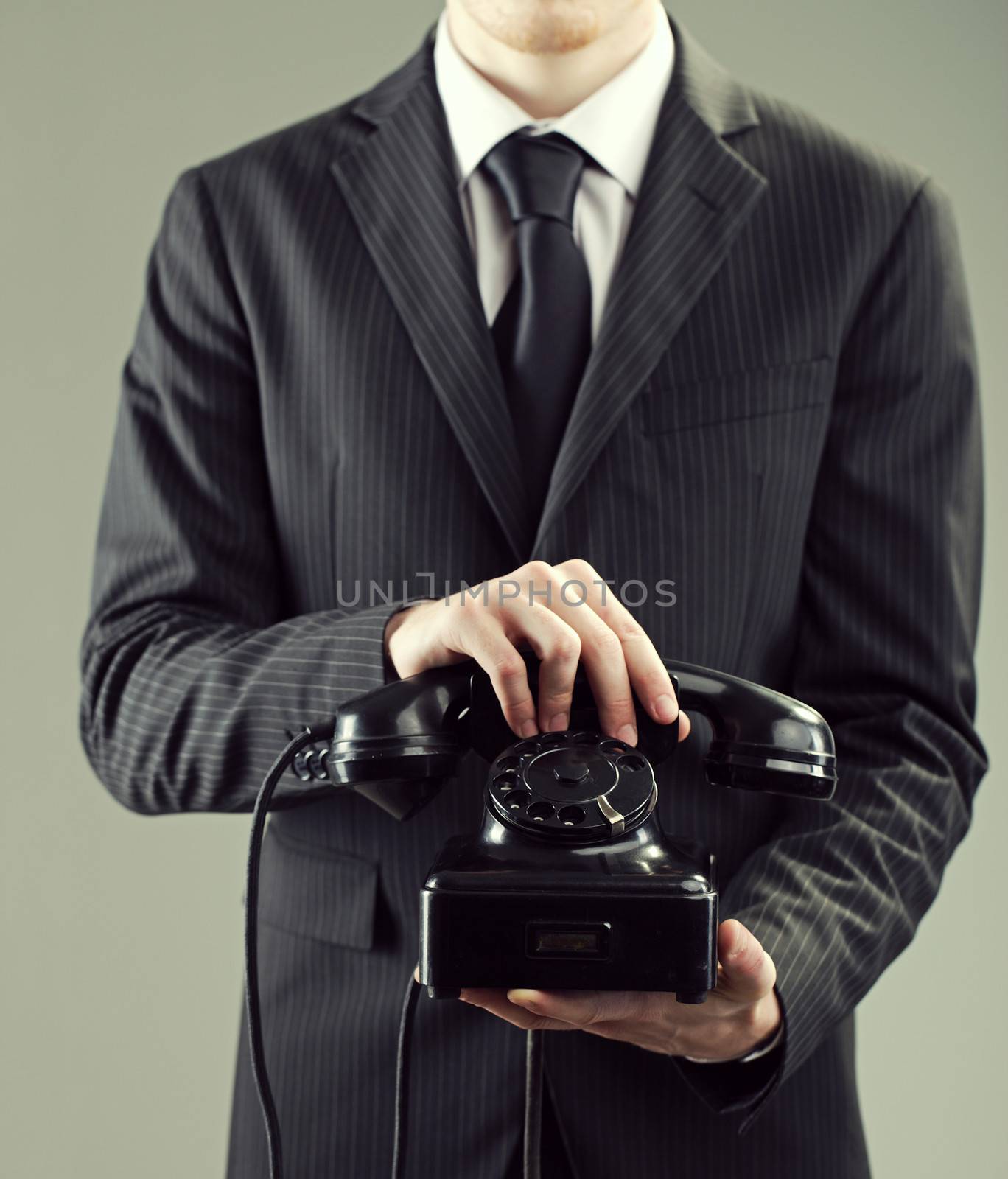 Elegant businessman holding an old black telephone