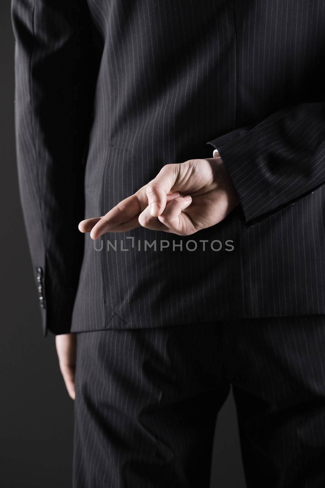 Business man or politician  with fingers crossed behind back 