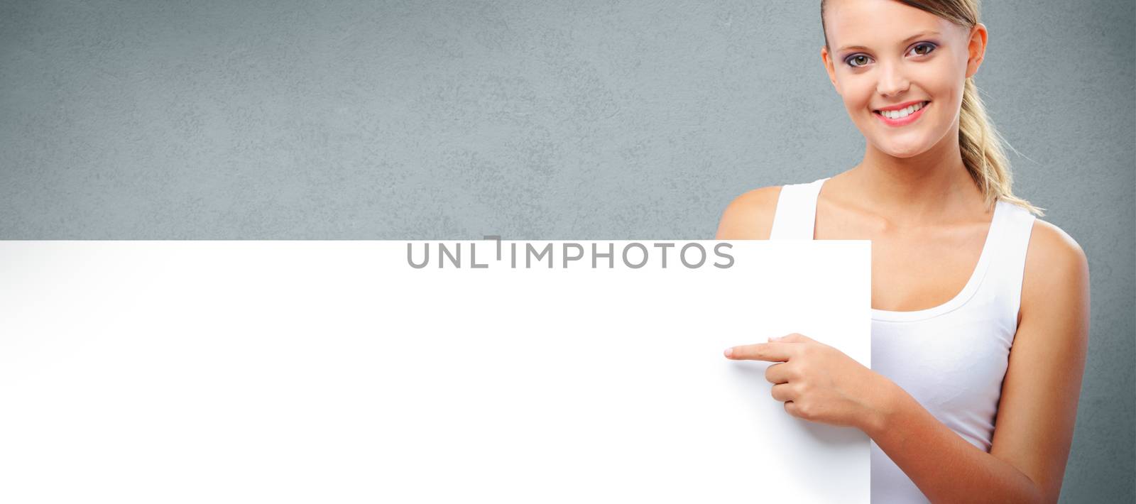 Portrait of a beautiful girl pointing at copy space