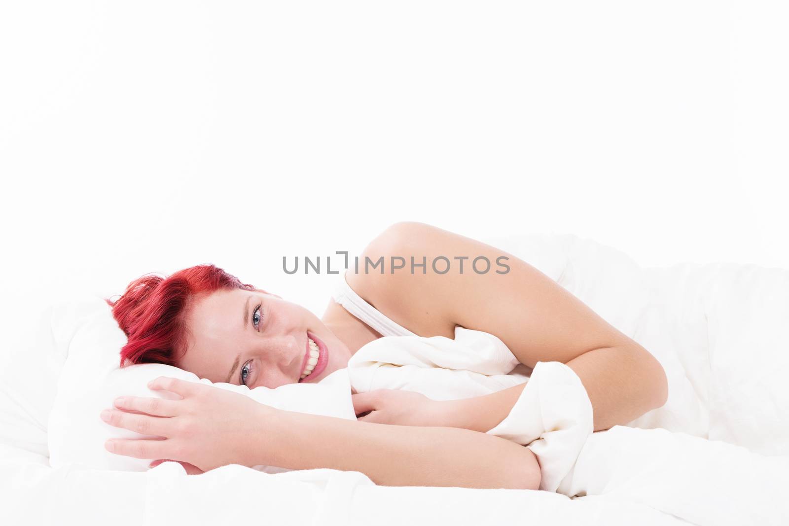 happy redhead woman in bed on white background