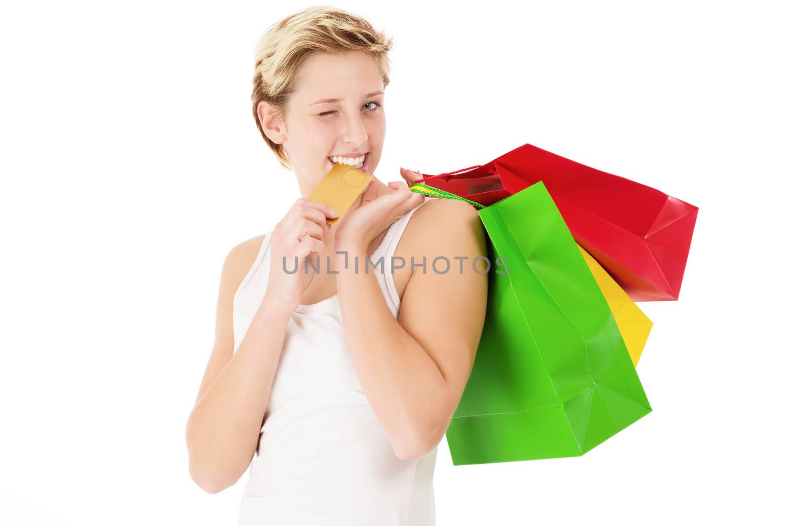 happy winking woman with shopping bags bites on her credit card on white background