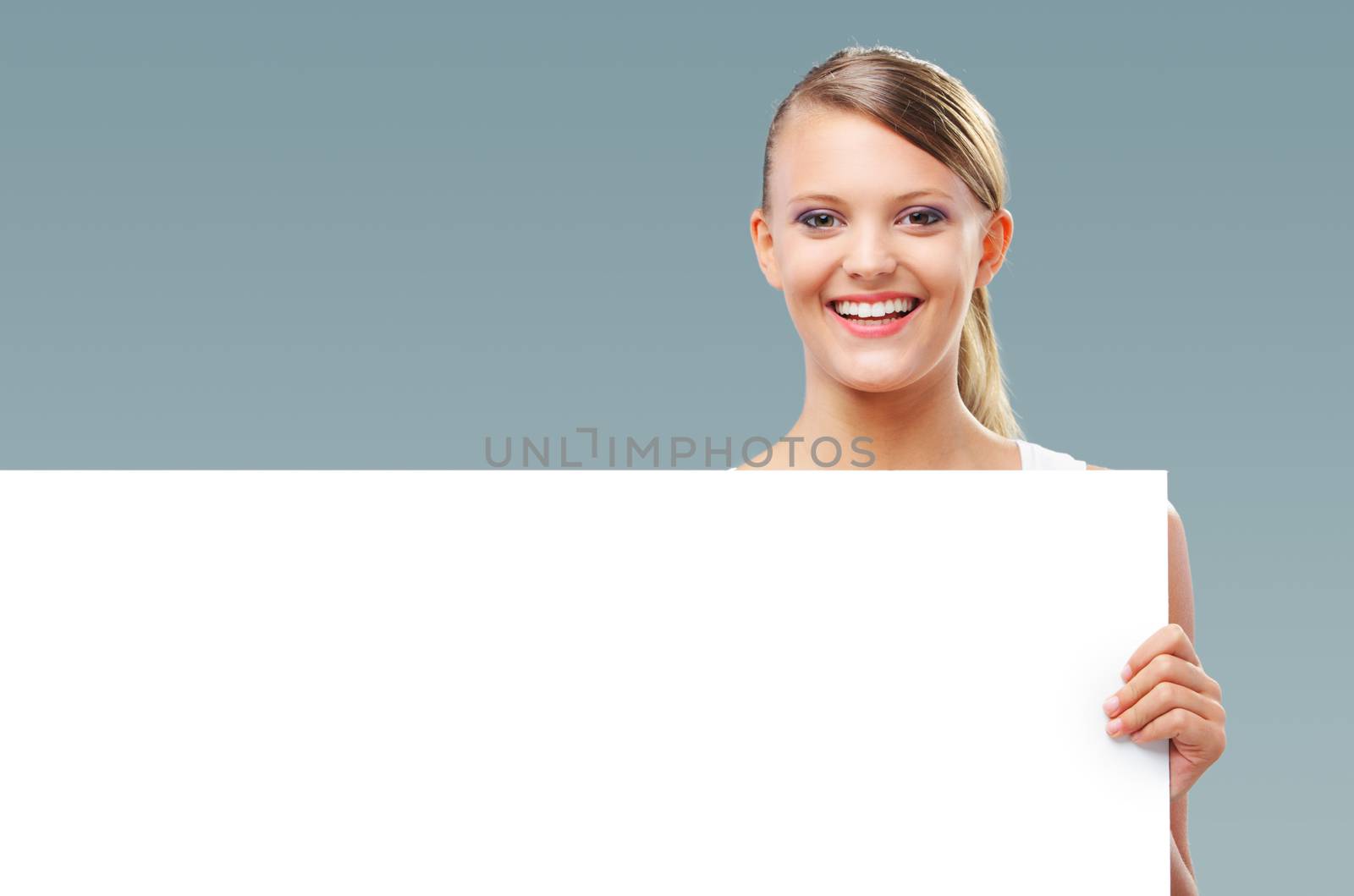 Happy blonde girl holding up a blank banner, copy space