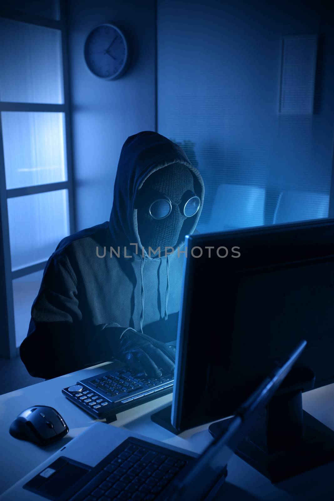 Young male thief stealing data from computer