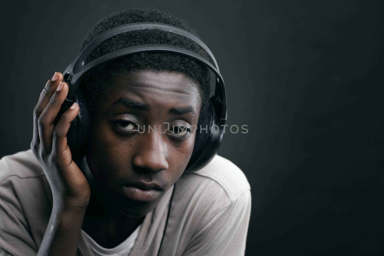 Portrait of african teenage listening music with headphones.