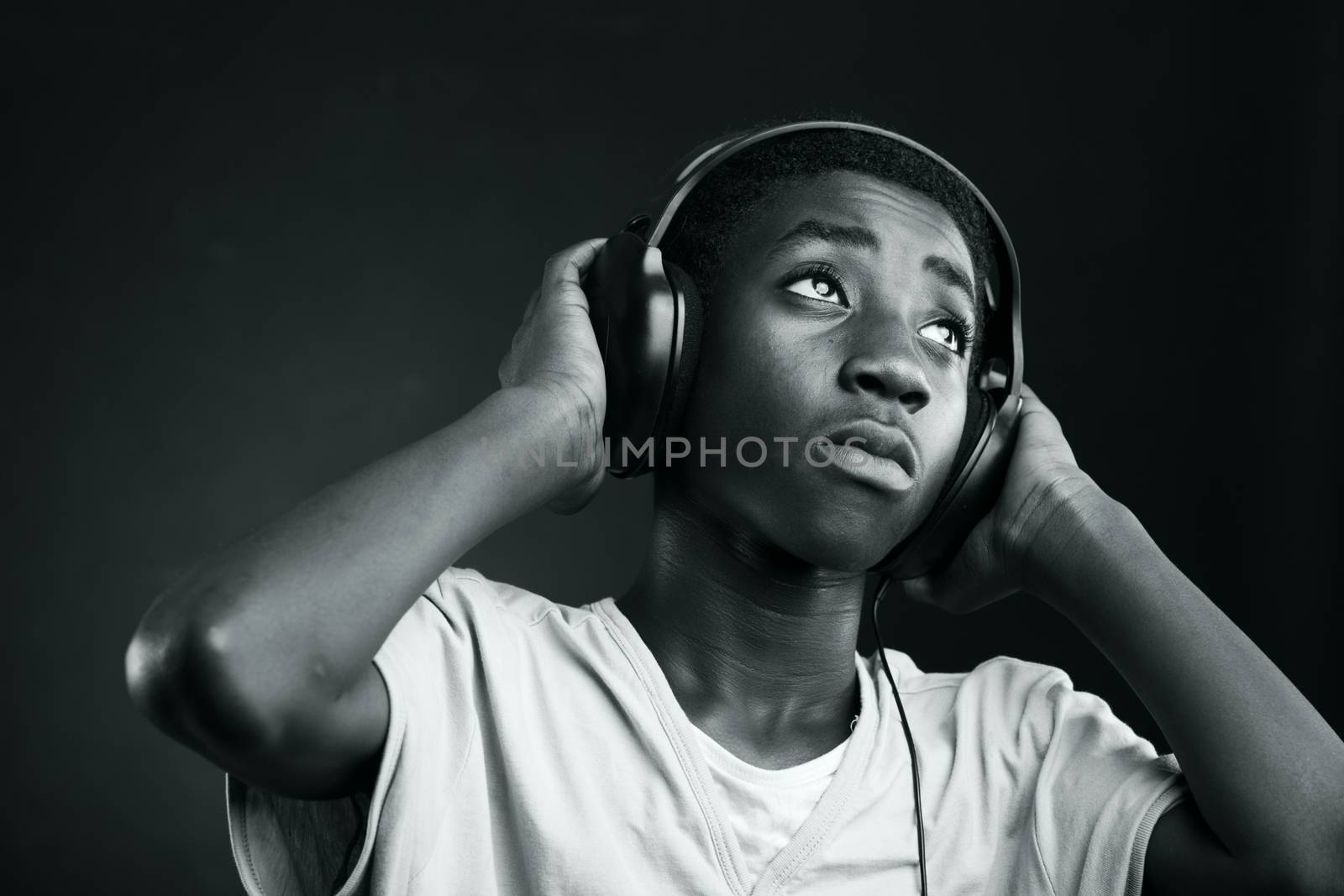 Portrait of african teenage listening music with headphones.