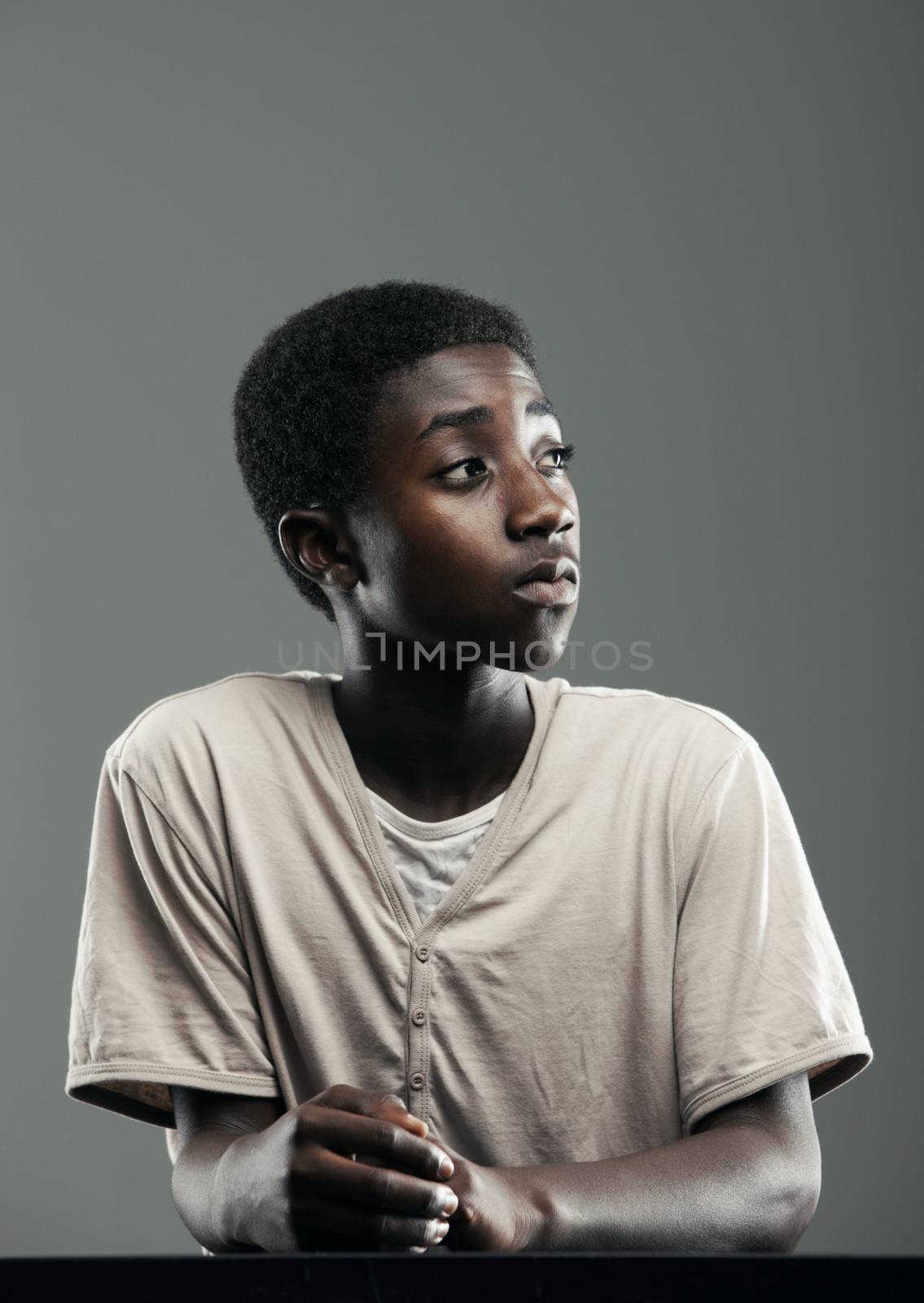 Portrait of male teenager on grey background