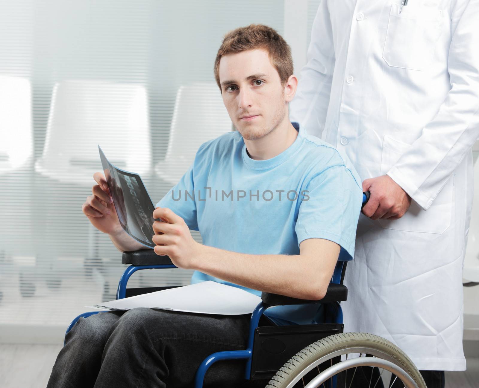 Disabled young man at doctor office by stokkete