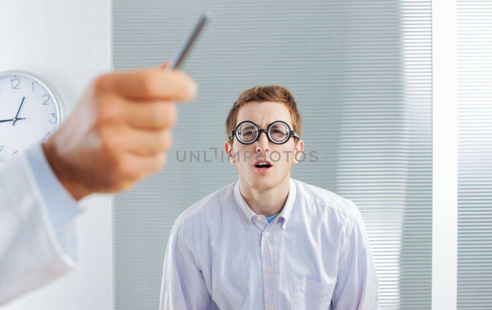 Optometrist pointing at eye chart, a nerd patient having difficulty