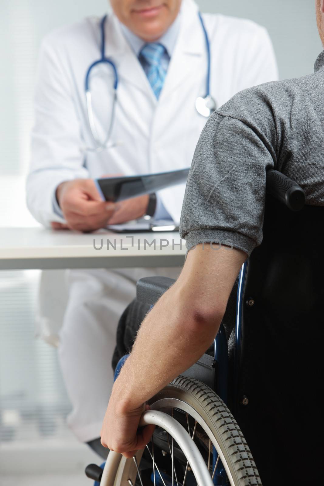 Young man on wheelchair meeting orthopedic doctor