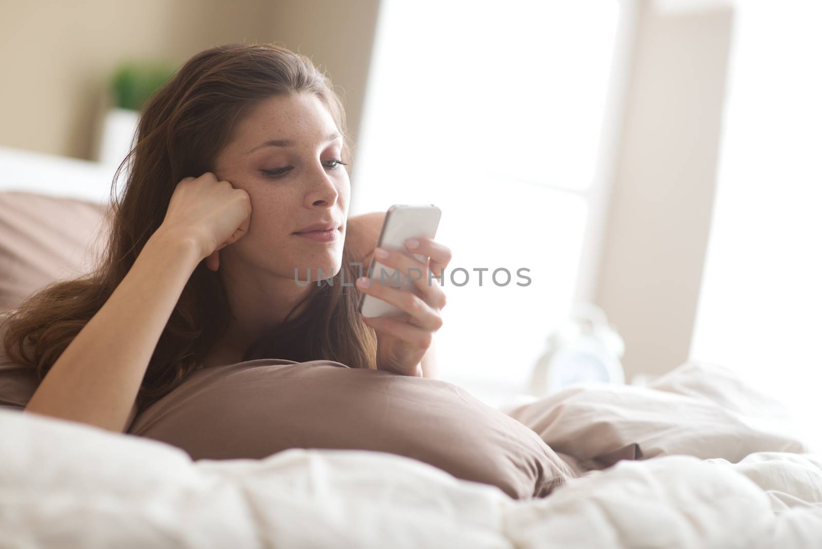 Woman relaxing on her bedroom by stokkete