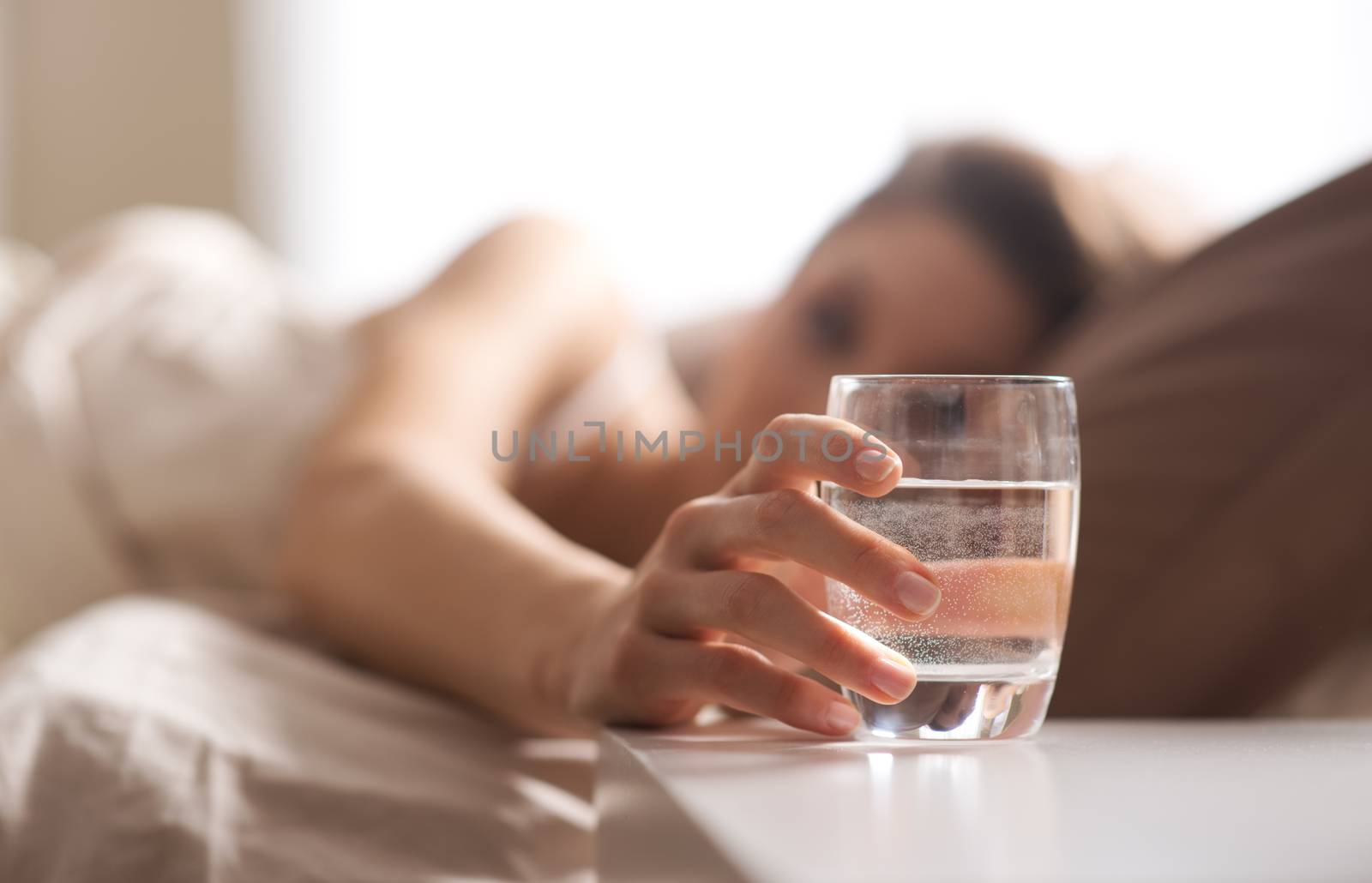 Close up of woman's hand taking a glass of water