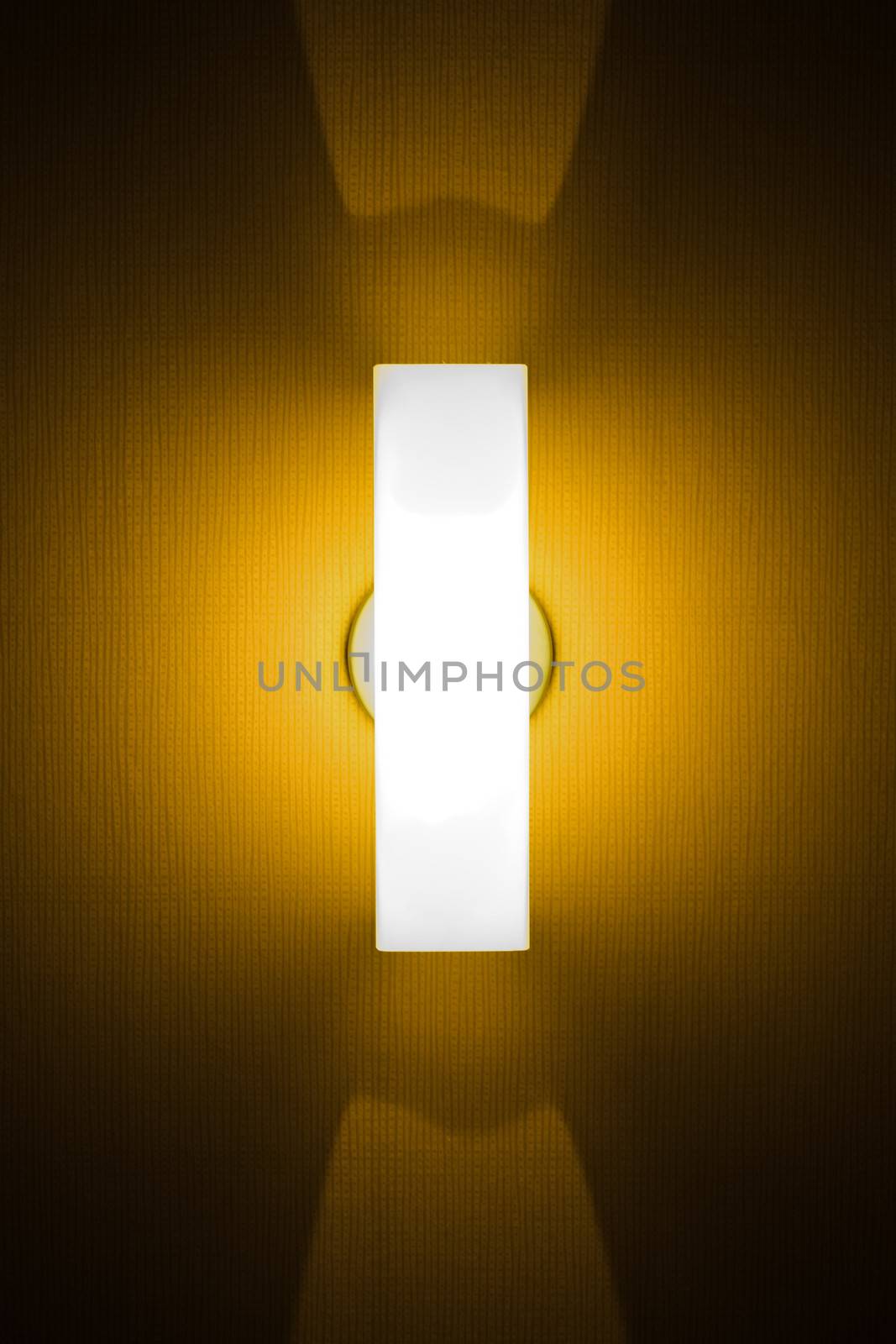 Tube of yellow neon light on textured wall