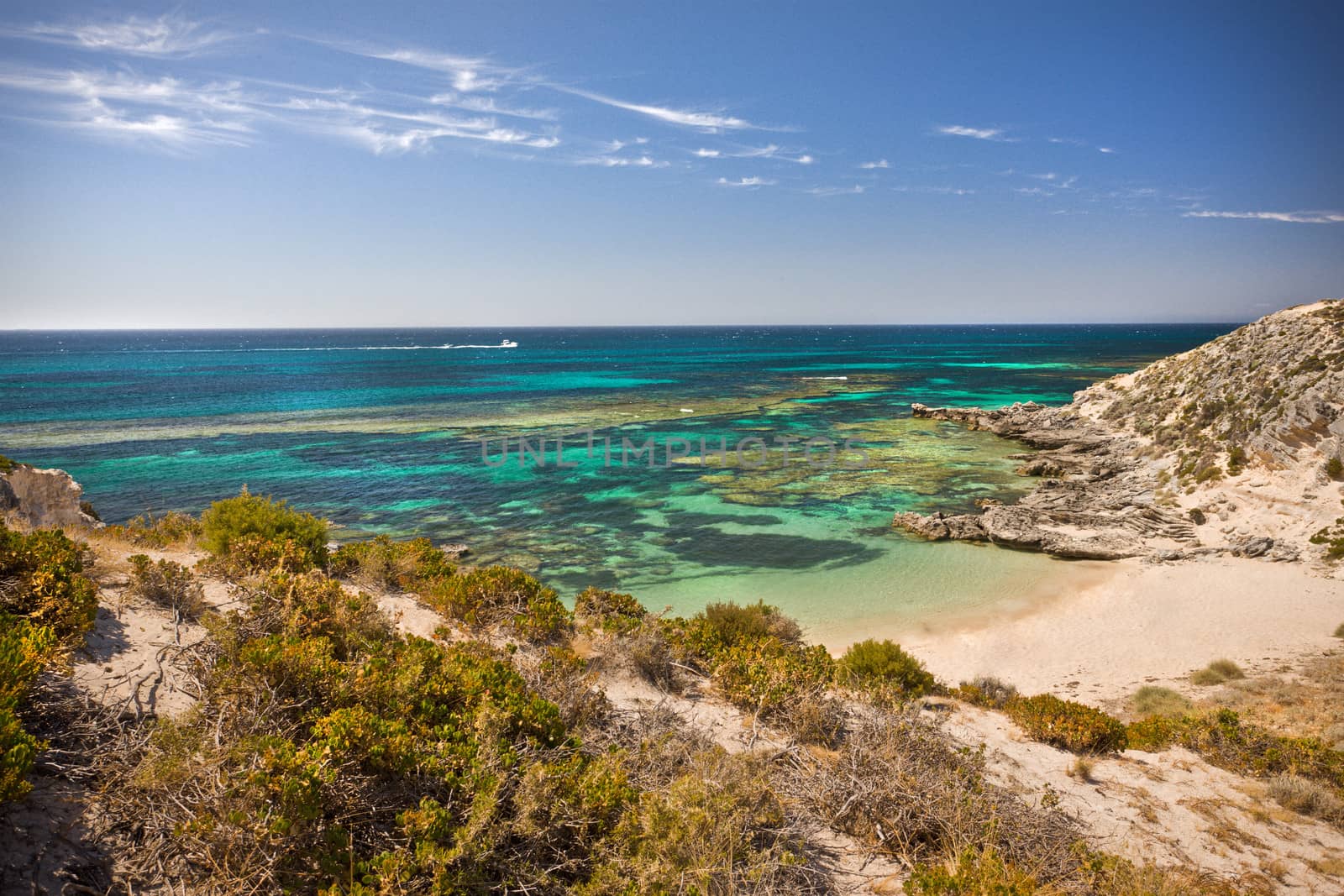 Beautiful peaceful tropical bay with sand dunes leading down to golden beach sand bordering clear blue water