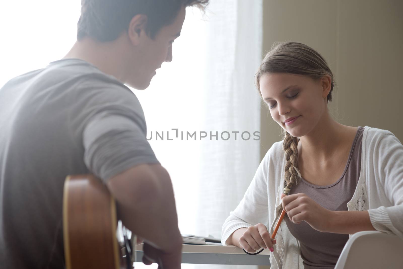 Young handsome man playing guitar for his girlfriend