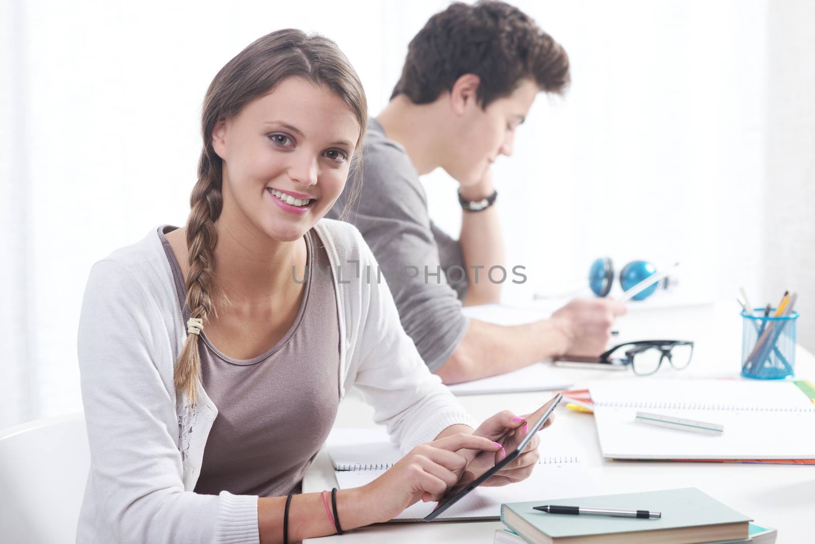 Teen boy and girl sitting together and studying 