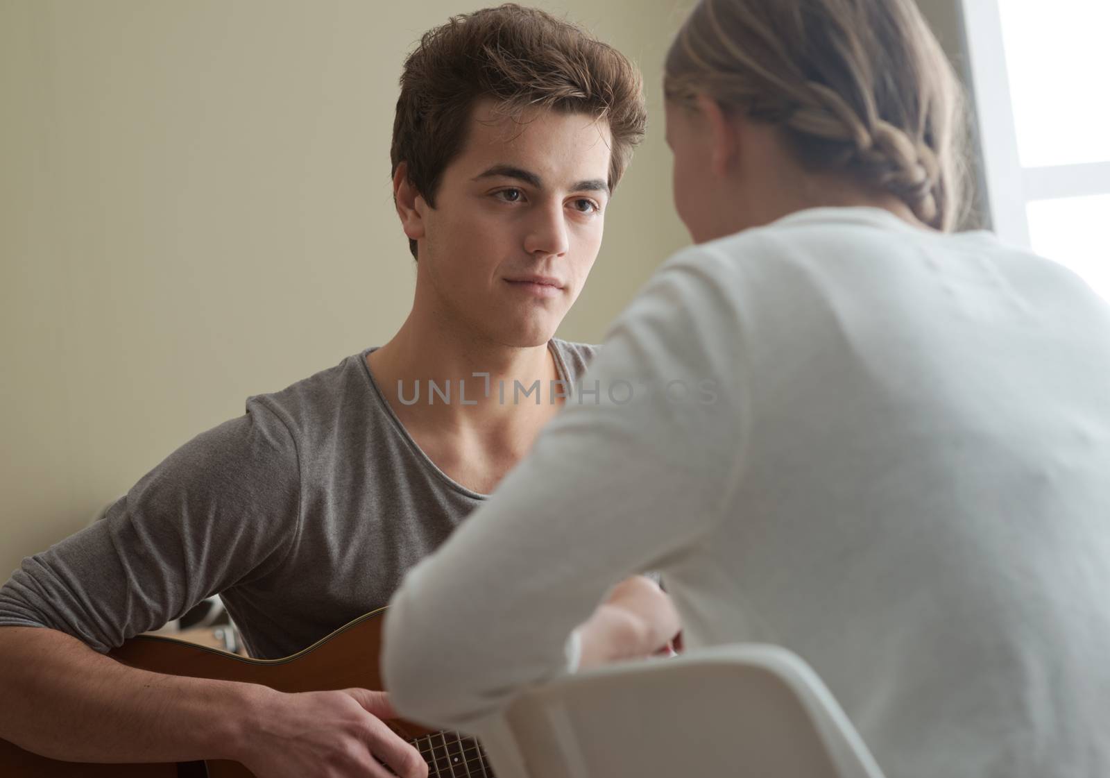 Beautiful boy playing guitar for his girlfriend