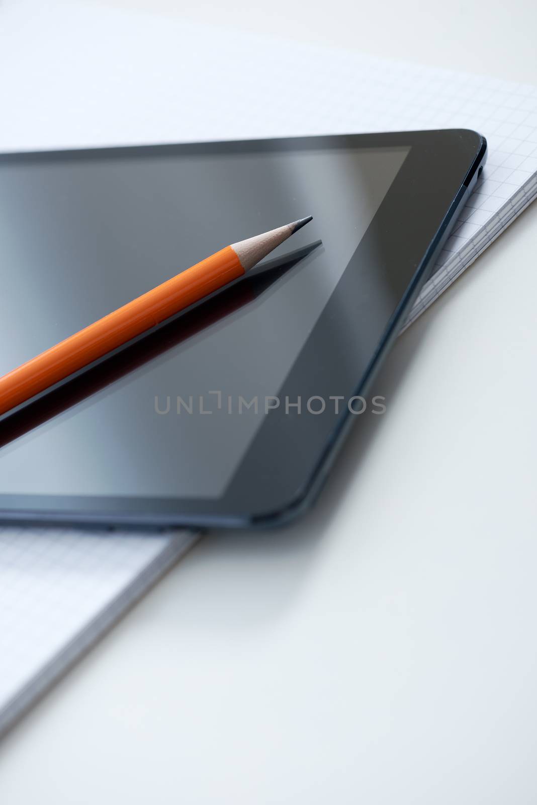 Tablet PC, blank papers and pen on the table.