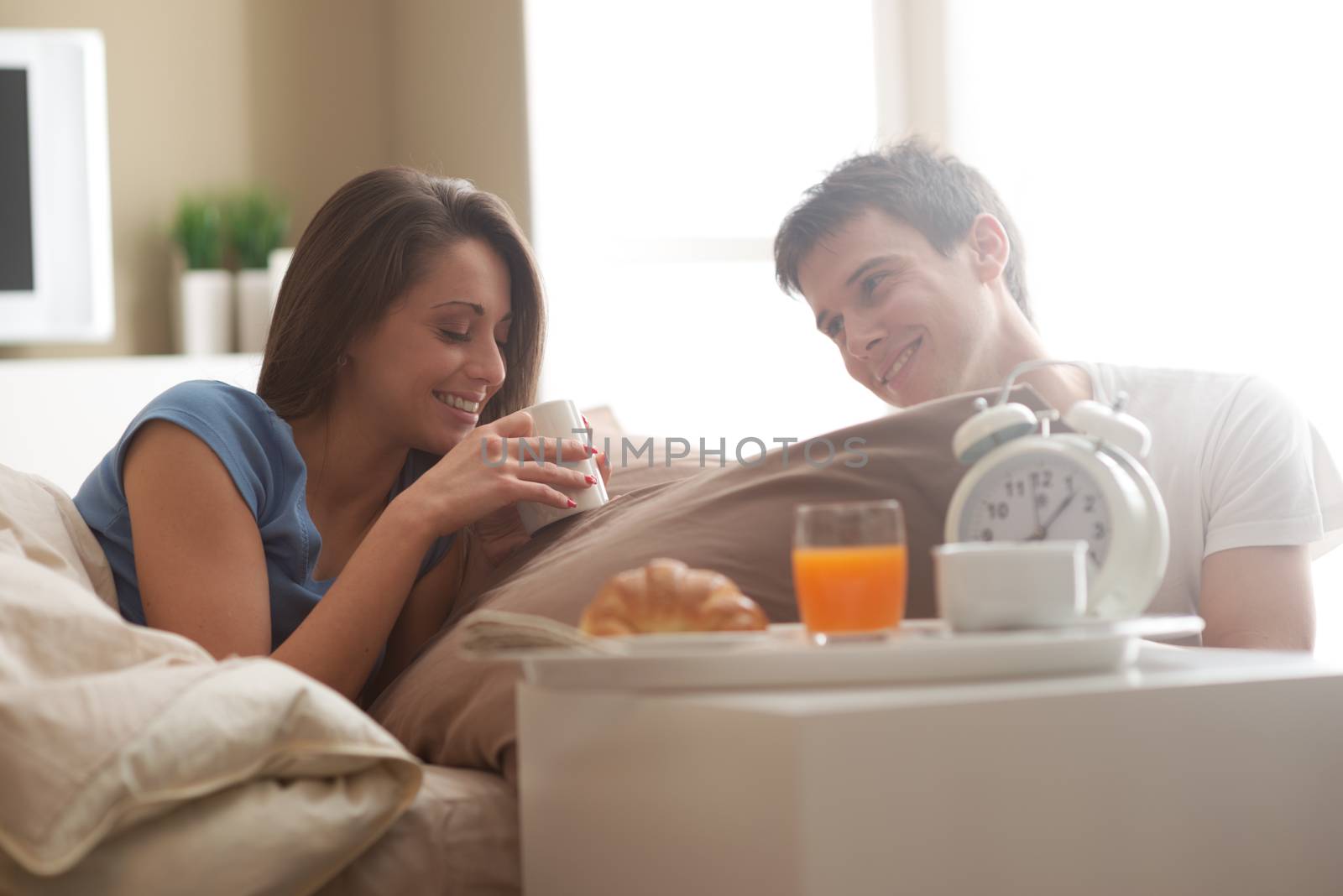 Couple having breakfast in bed by stokkete