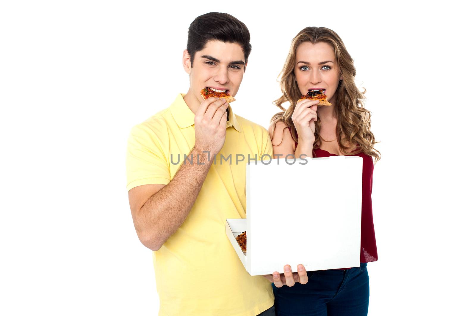 Couple enjoying pizza slices by stockyimages