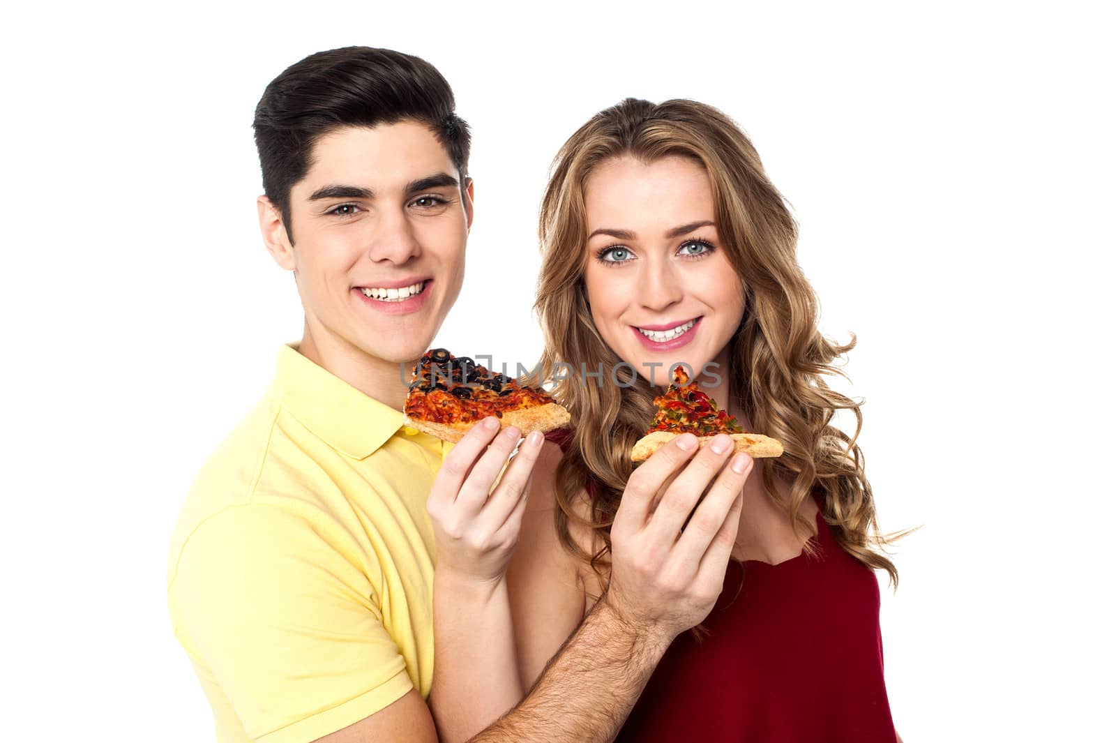 Couple enjoying pizza slices together by stockyimages