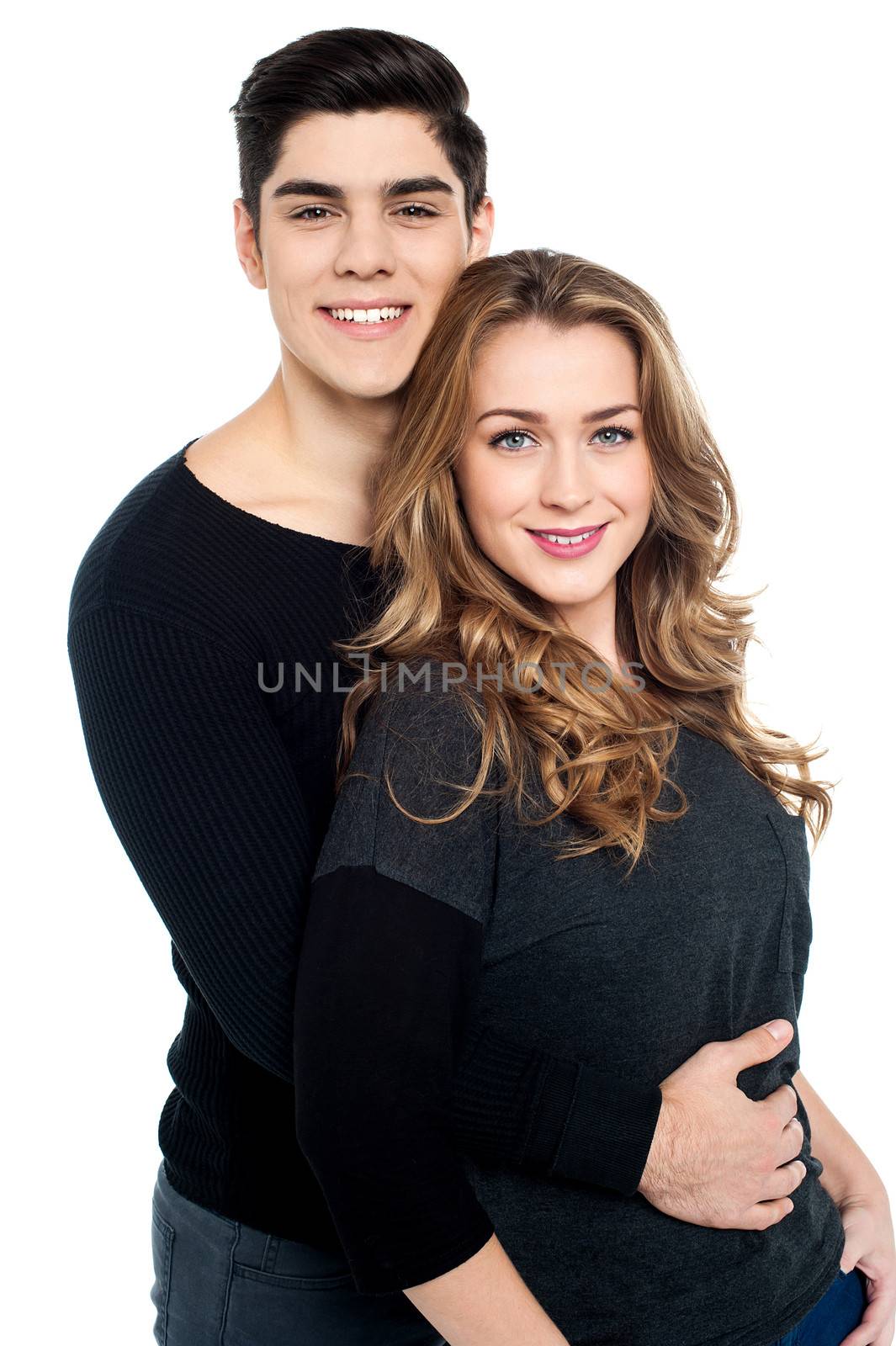 Guy with arms around her girlfriend's waist by stockyimages