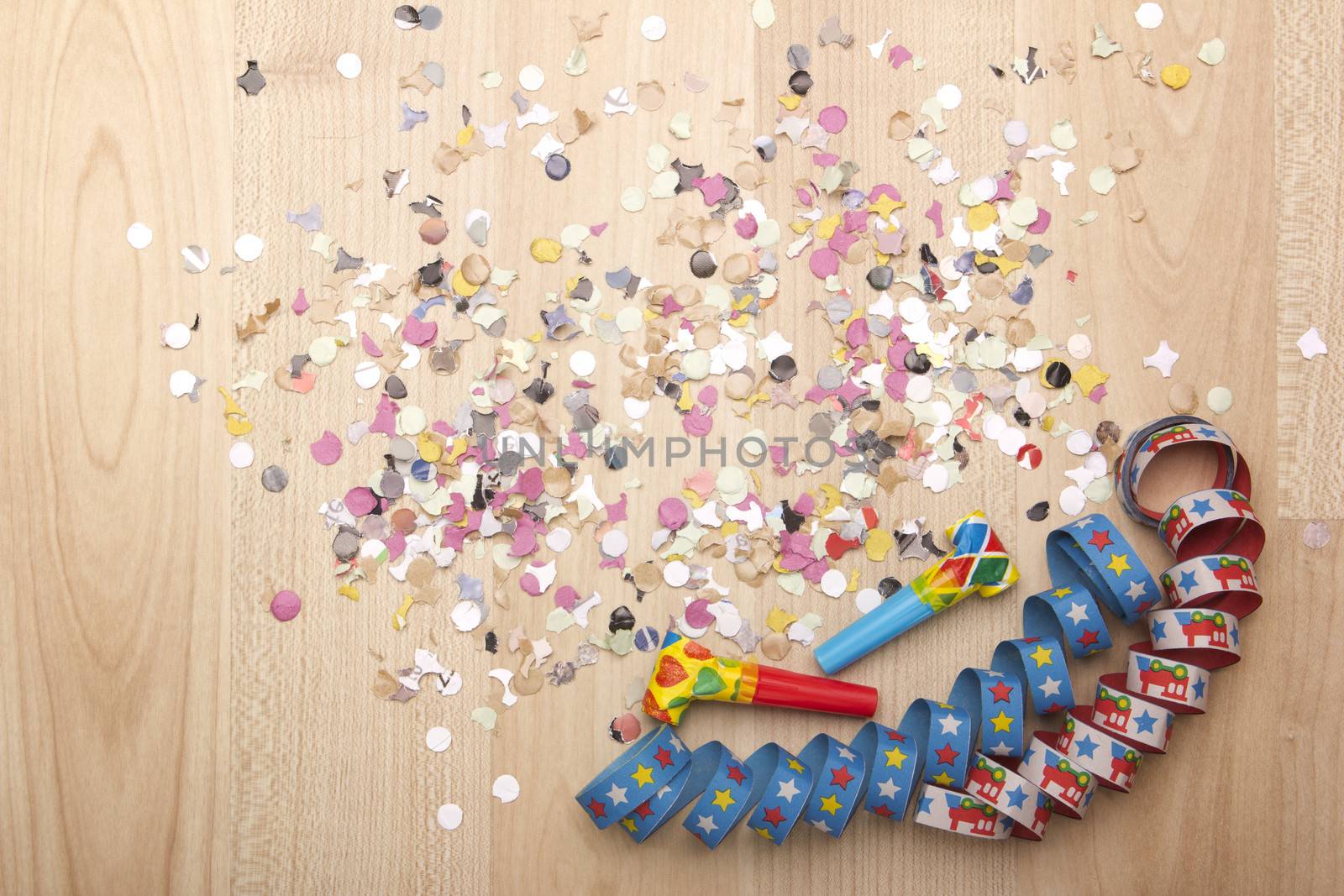 streamers and confetti as decoration for parties, sylvester with wooden background