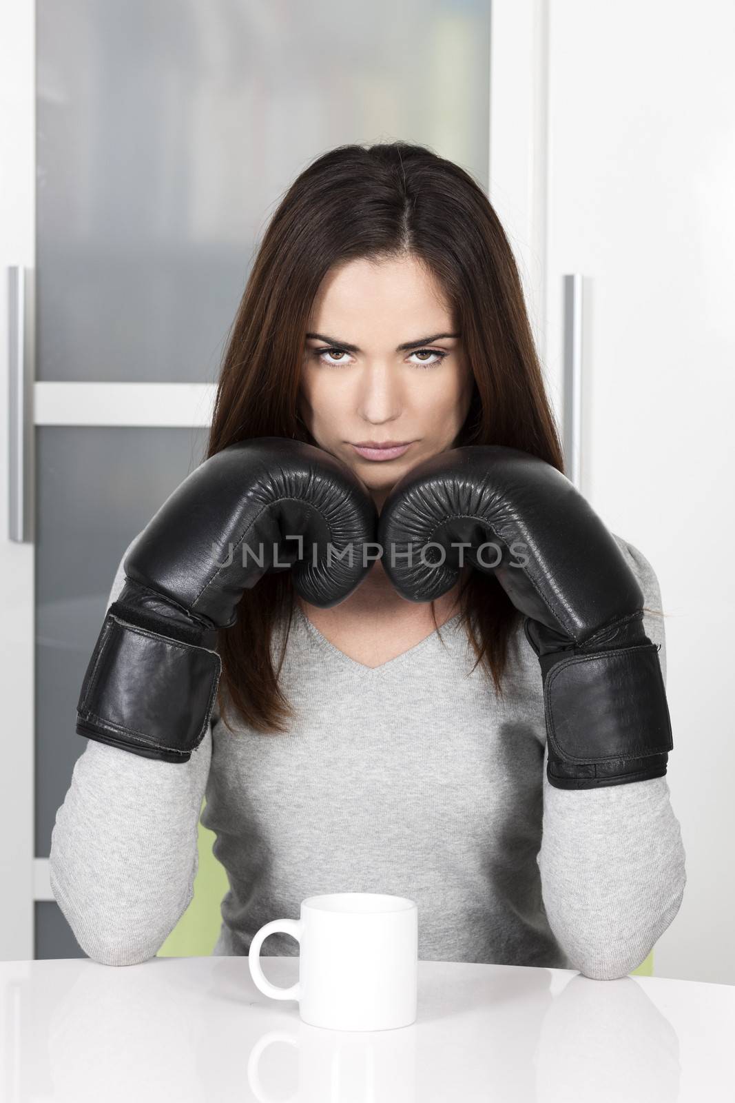 very tired looking woman early in the morning drinking a cup of coffee