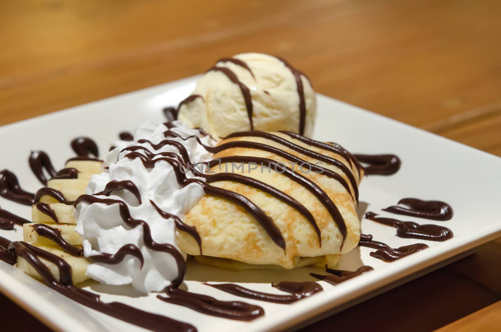 Crepes with banana , chocolate sauce  served with whipping cream and vanilla ice cream