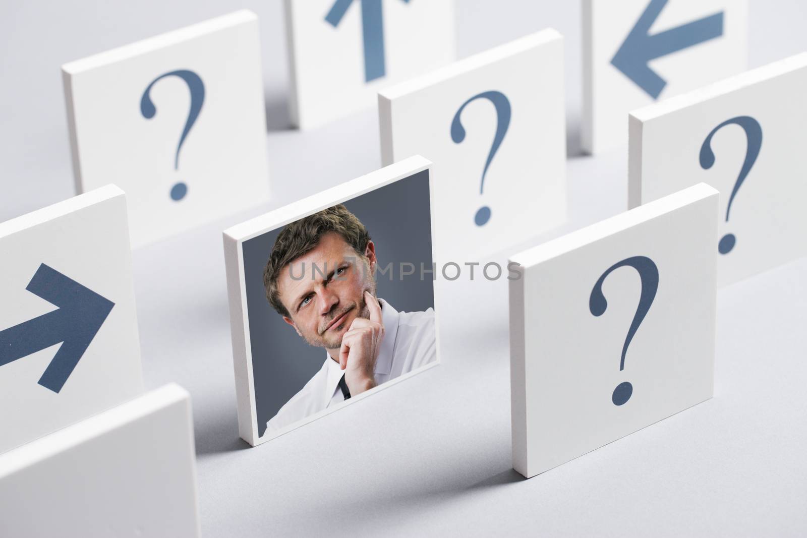 Portrait of a confused businessman surrounded by question marks and arrows