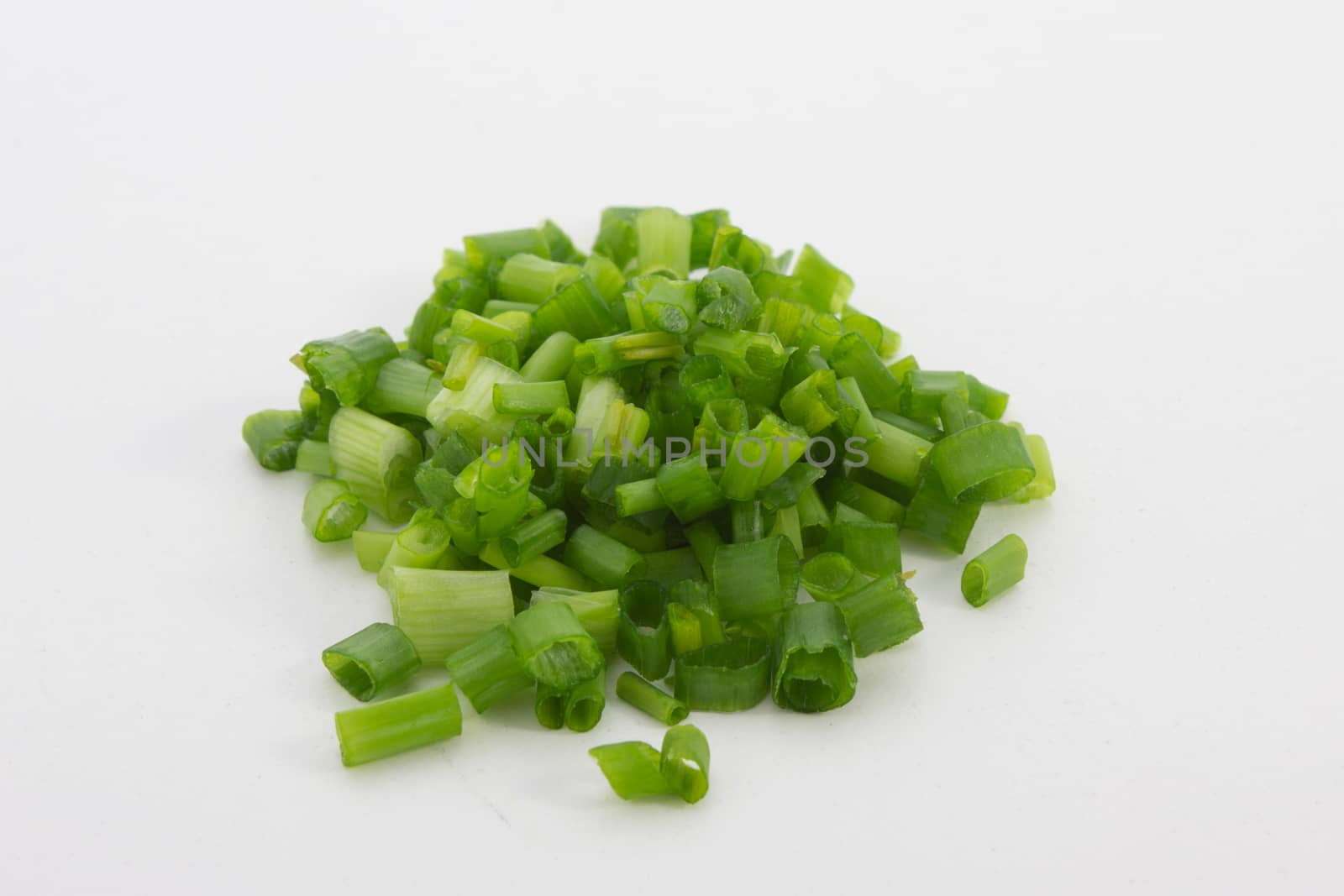 A close up image of chopped spring onions on a white background