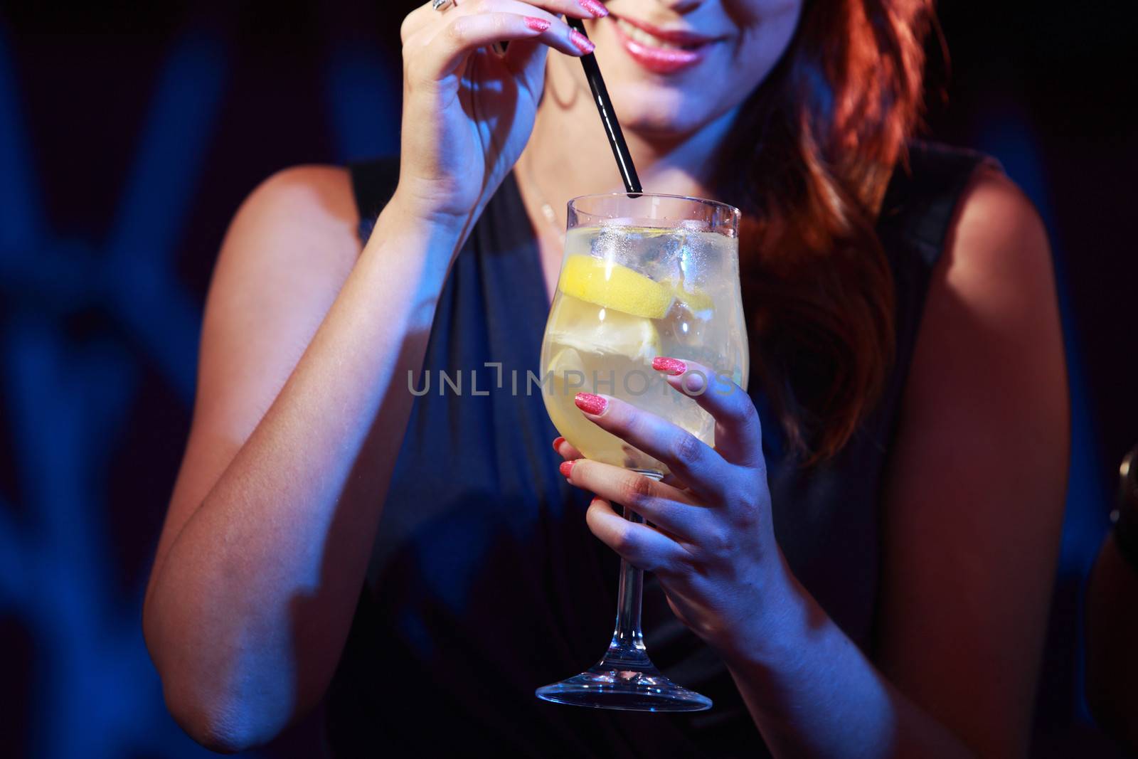 Young woman holding a cocktail glass, hands close up