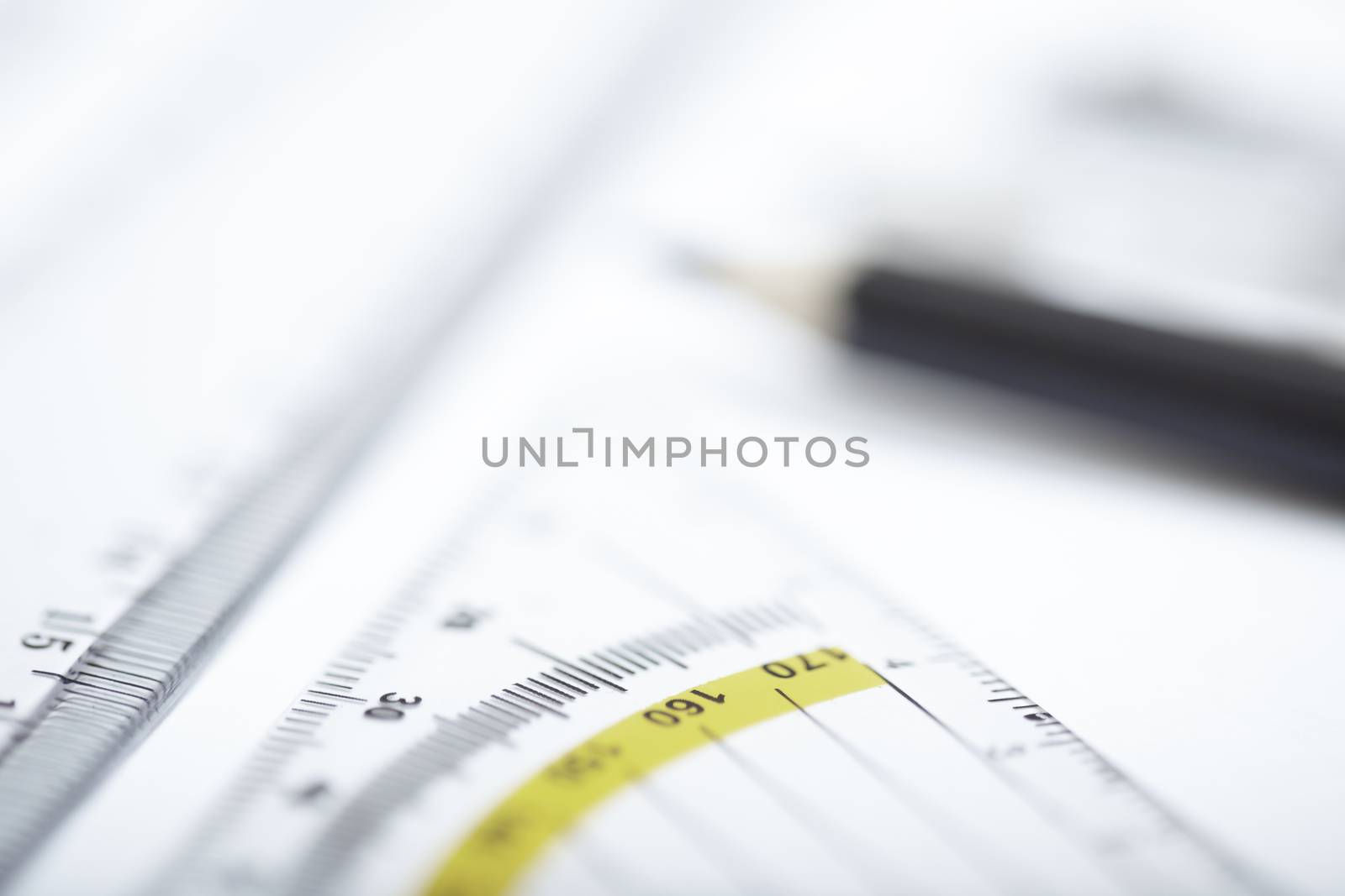 Drawing tools on a paper. Extremely close-up photo with shallow depth of field. Focus on ruler