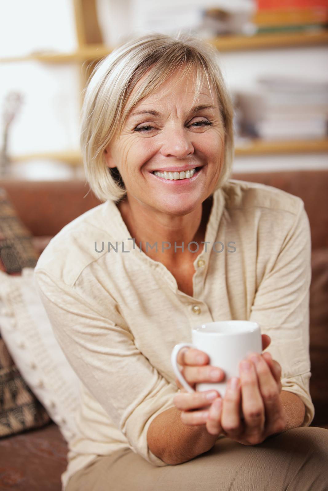 A cheerful senior woman enjoying a cup of coffee 