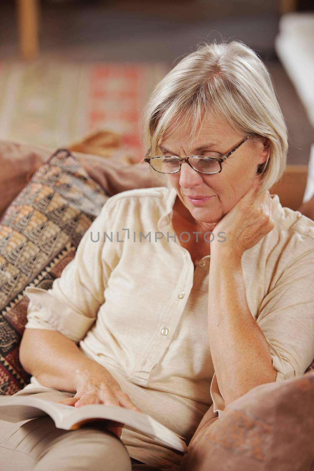 Mature Caucasian woman reading a book at home