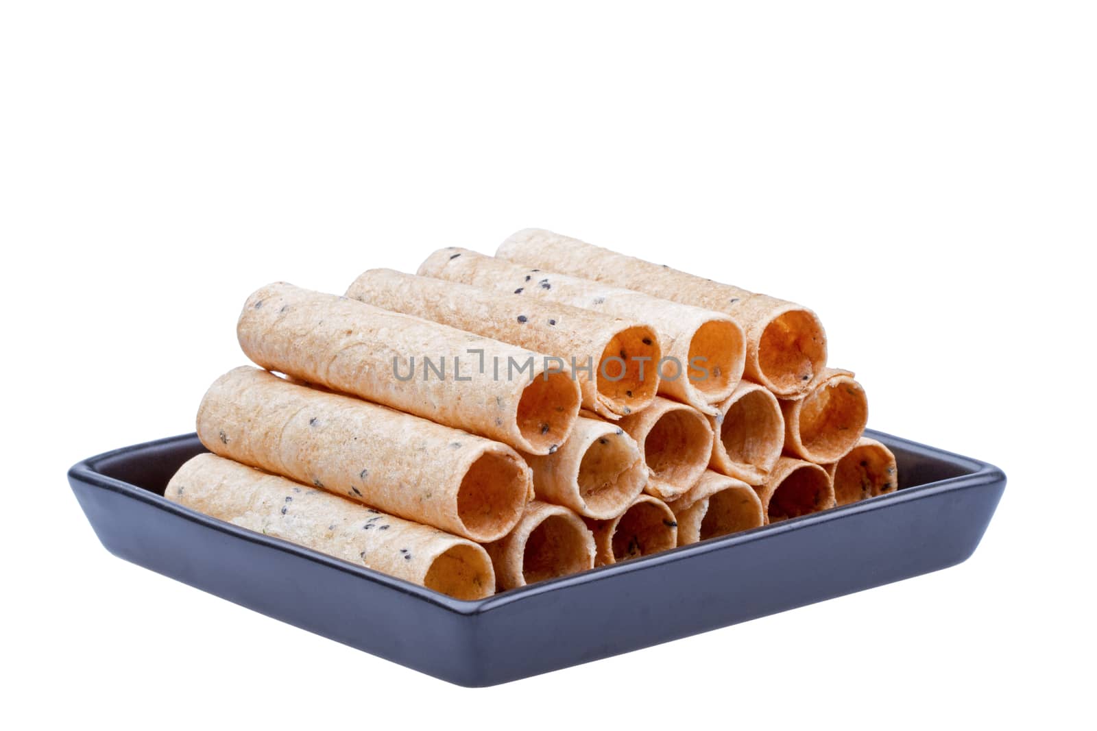 rolled wafer called "thong muan" made from flour, egg, sugar, sesame, coconut milk on black dish isolated on white