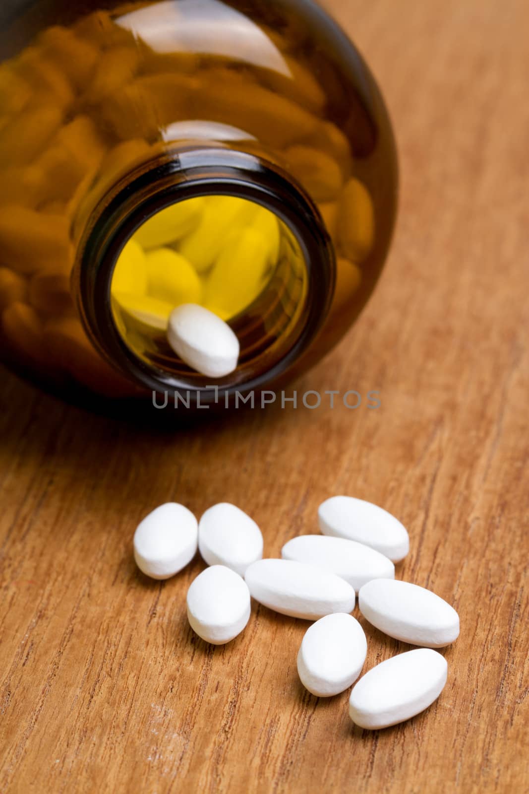 white pill with bottle on wooden plate