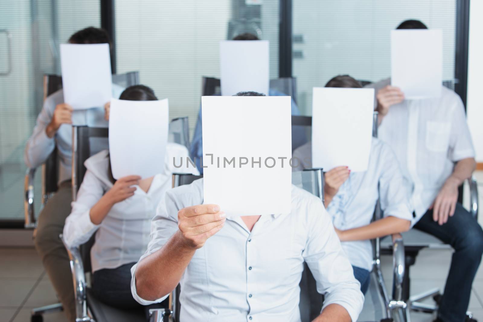 A group of business people holding a blank placard in front of face 