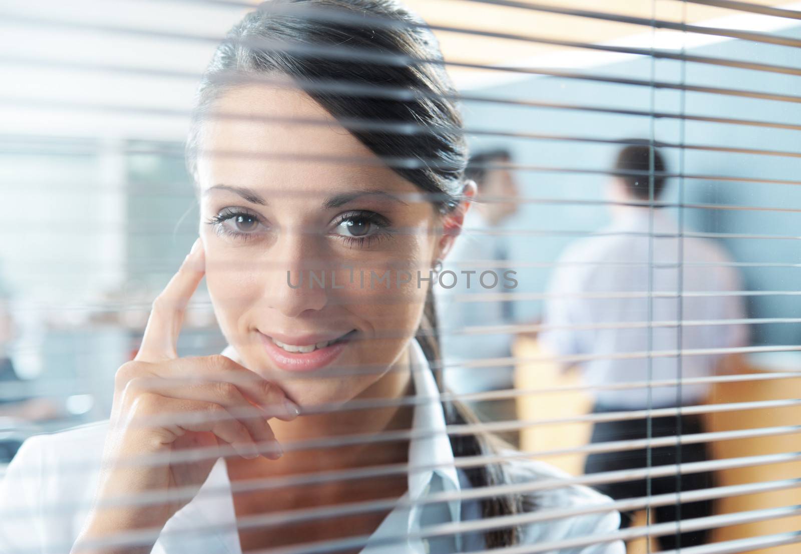 A smiling executive standing at a window in his office
