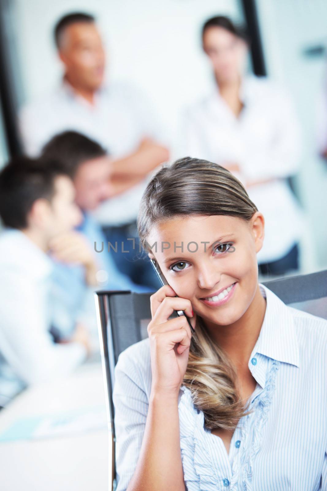 Portrait of a pretty young business woman at cell phone, meeting on background