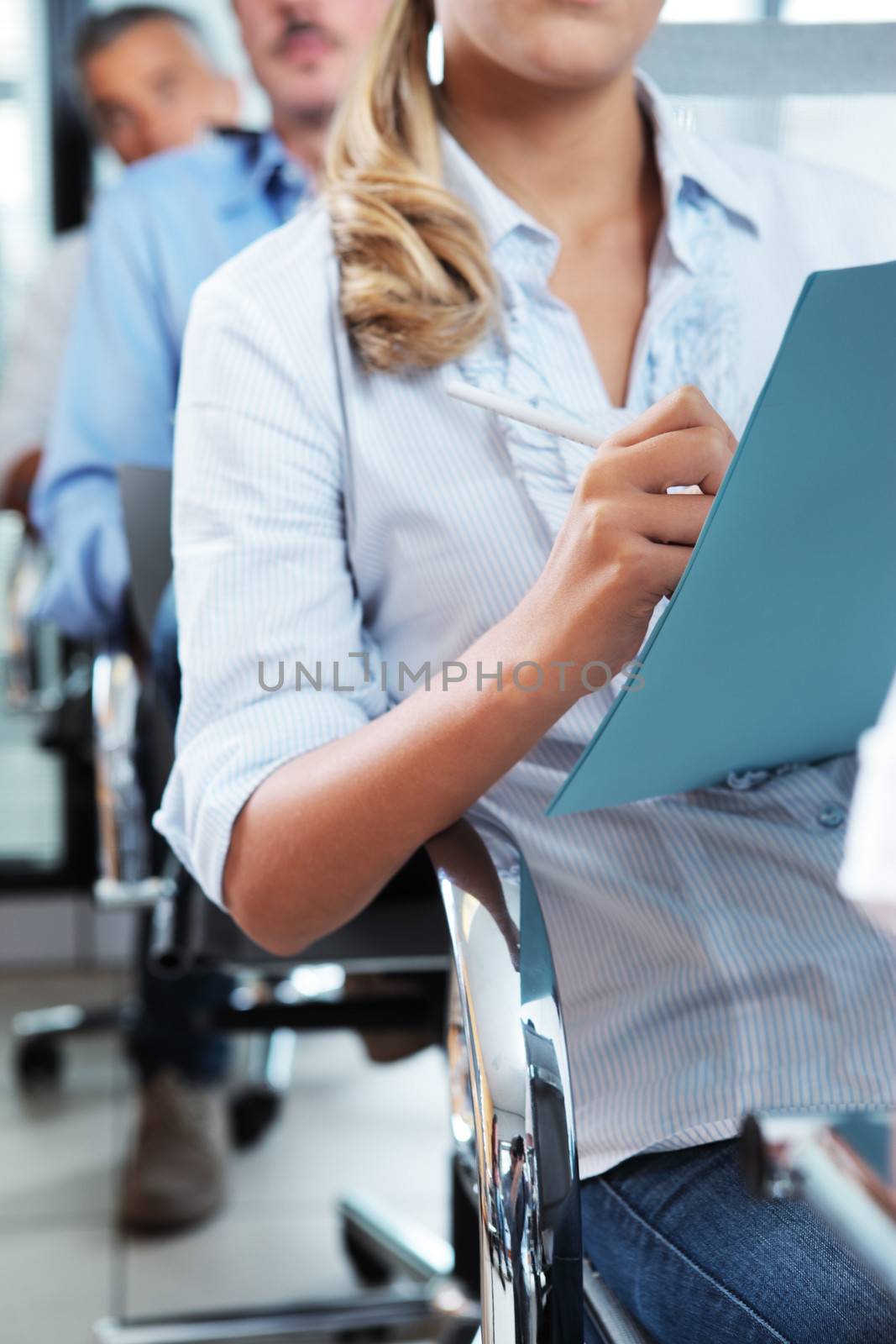 Business colleagues taking notes during a seminar, hand close up 