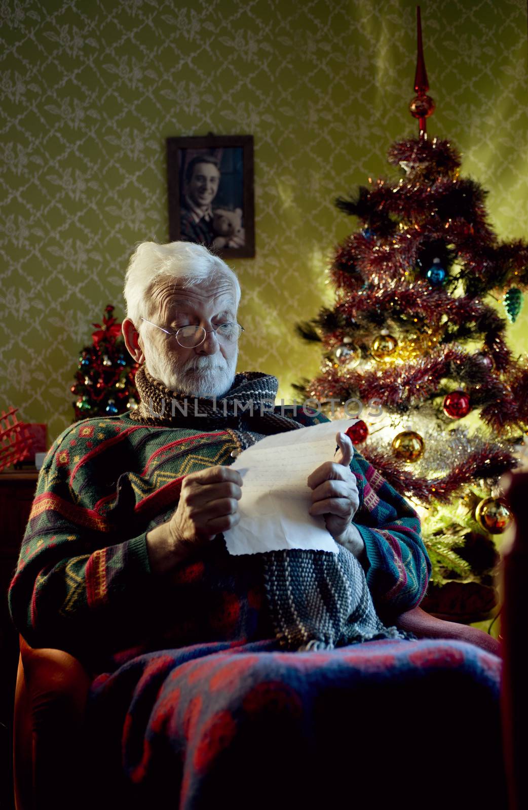 Portrait of Father Christmas sitting in armchair reading letters