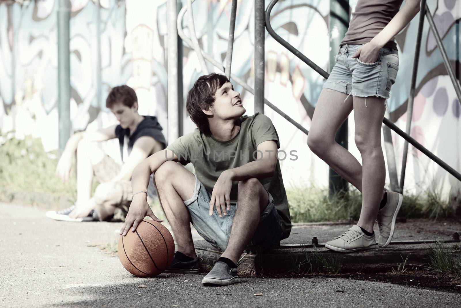 Group of friends taking a break after playing basketball