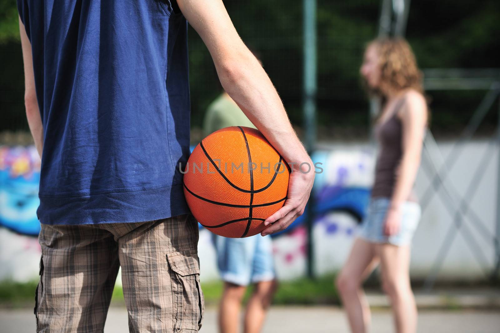 Group of friends talking and taking a break after playing basketball