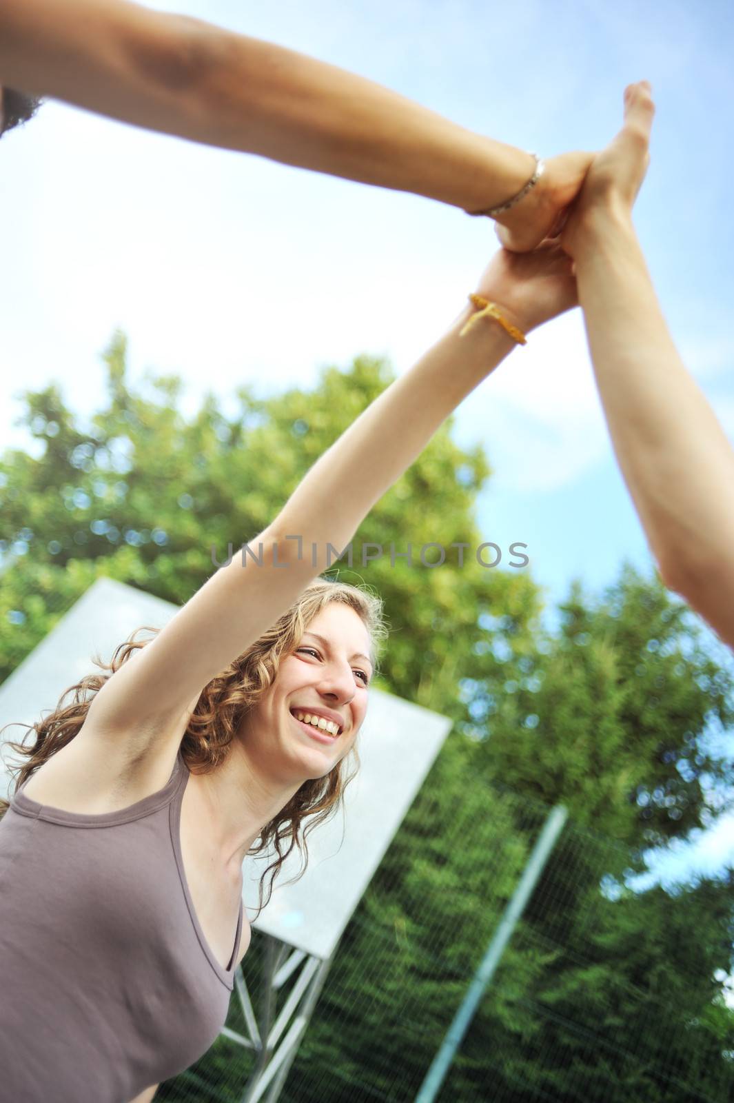 Three teenagers giving a high five, hands close up