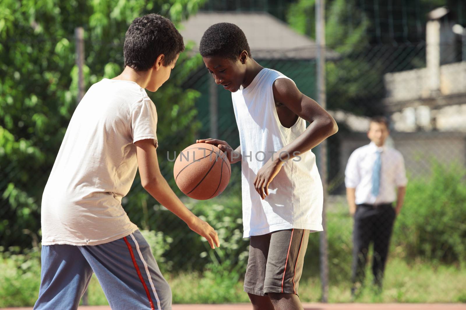 Two young African boy play basketball outdoors