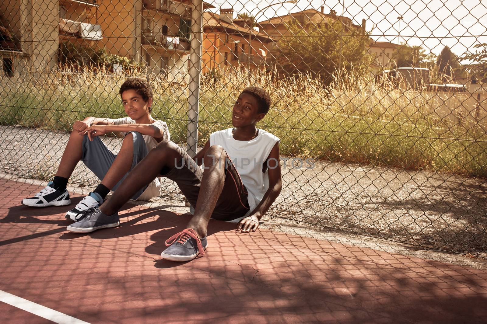 Two young African boy resting outdoors 