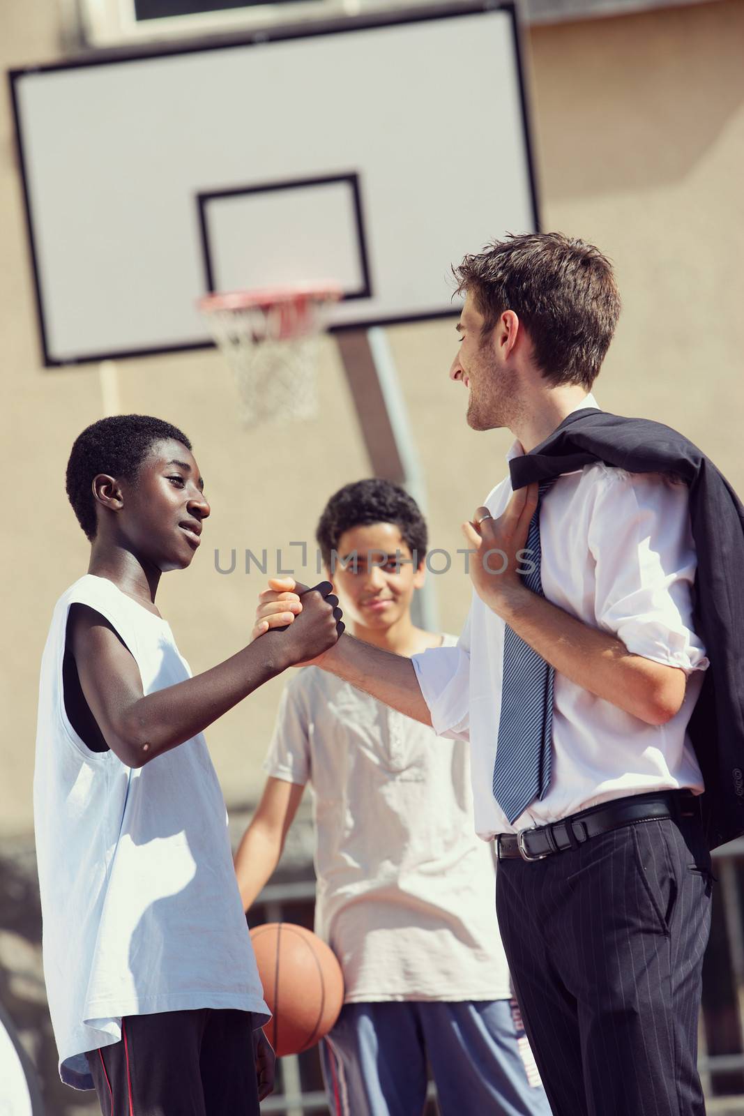 Multi-Ethnic Basketball players shaking hands after match