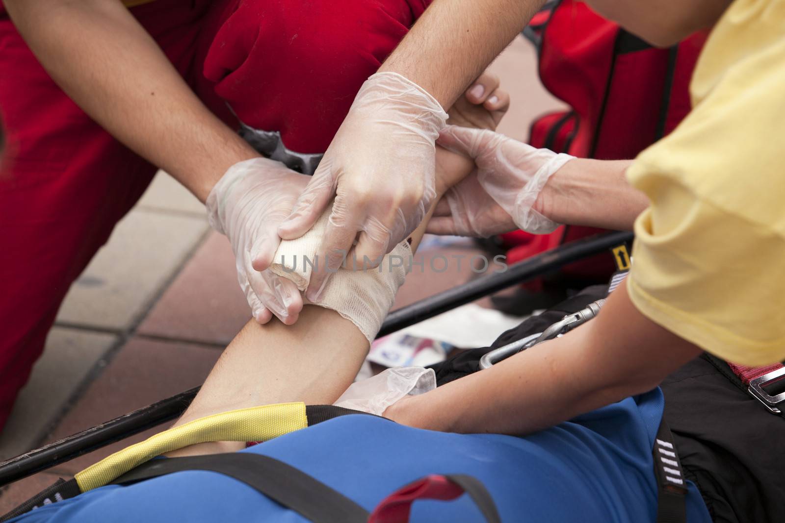 Paramedics putting a bandage on an injured hand