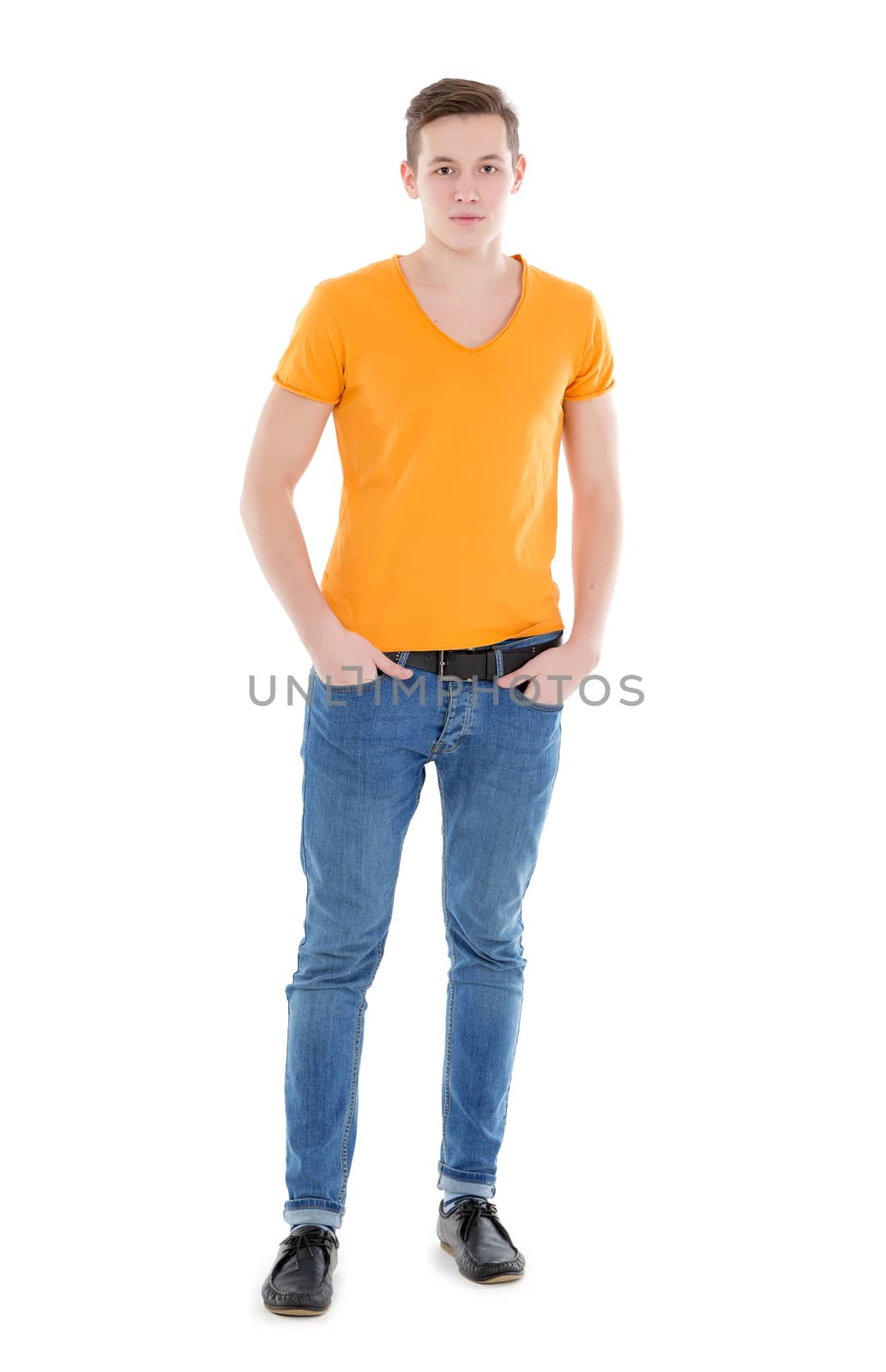 Young man, wearing a yellow T-shirt and slim jeans, standing on white background