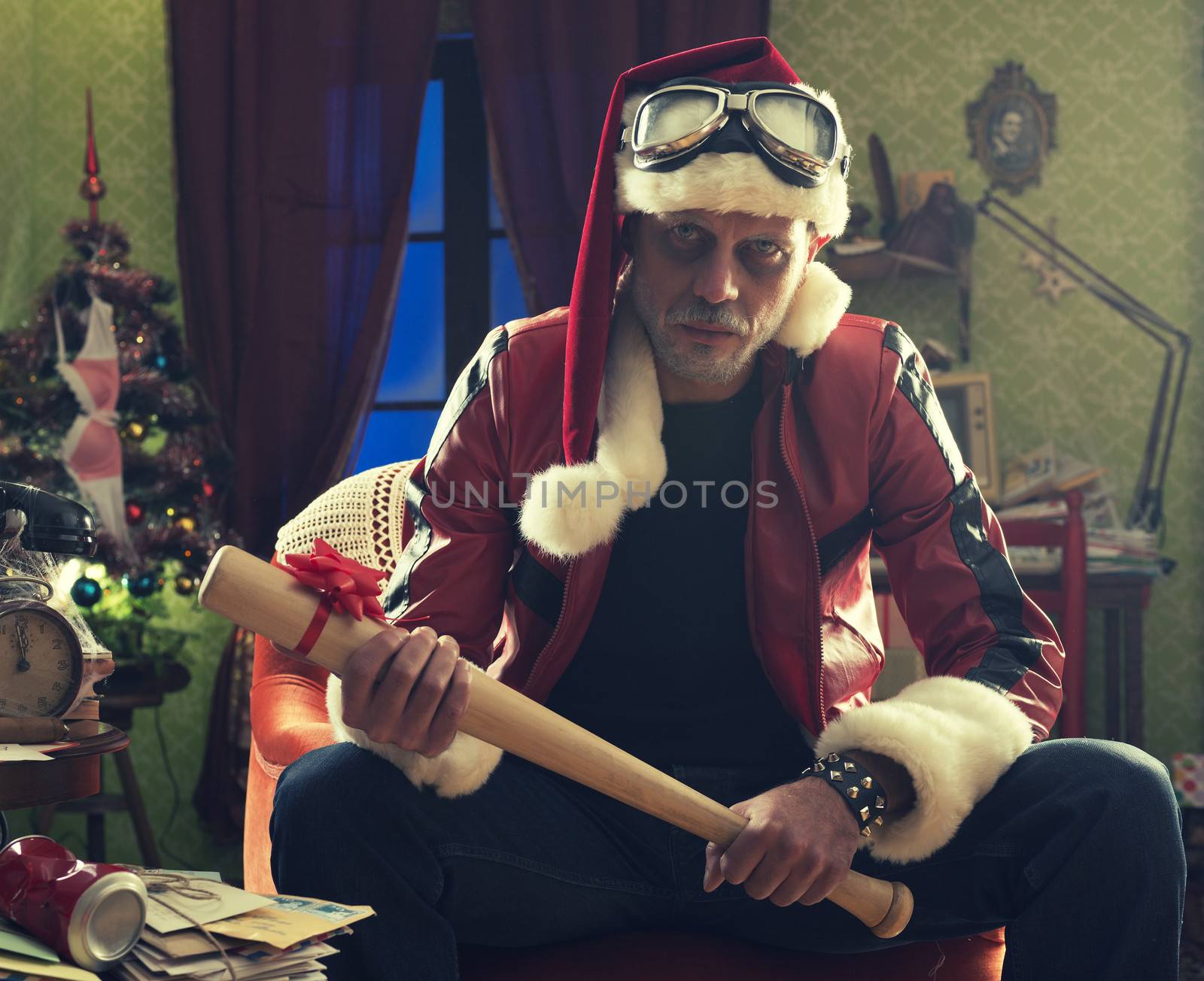 A frowning Bad Santa with baseball bat looking at camera